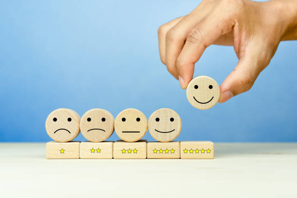 istock Customer service evaluation and satisfaction survey concepts. The client's hand picked the happy face smile face icon and five star symbol on wooden cube on table 1757217479