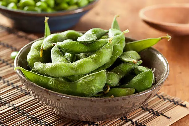 Cooked Green Organic Edamame with sea salt against a background