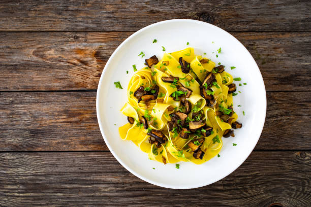 istock Tagliatelle with forest mushrooms on wooden table 1757230476