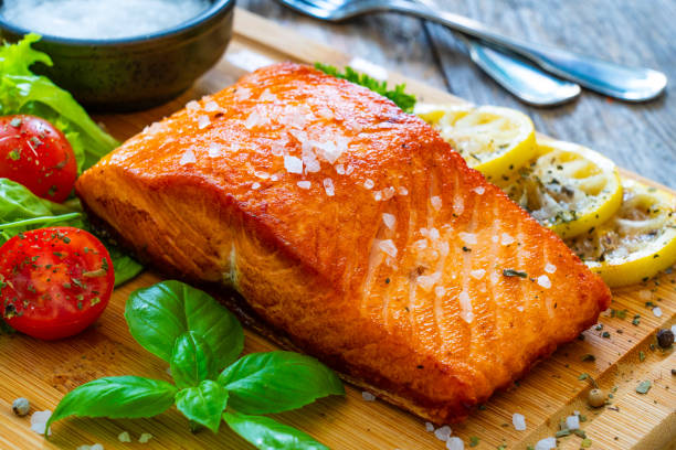 istock Seared salmon with fresh vegetables on wooden table 1757232591