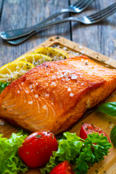 istock Seared salmon with fresh vegetables on wooden table 1757233108