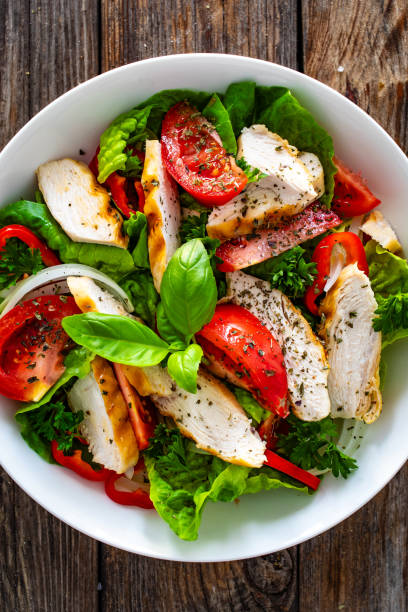 istock Caesar style salad  - fresh vegetables with grilled sliced chicken breast on wooden table 1757236726