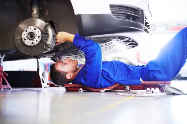 Concentration is key A car mechanic working on the underside of a car mechanic working under car stock pictures, royalty-free photos & images