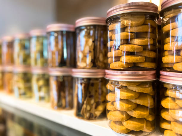 istock Many glass jars with caps filled with cookies on defocused background with reflection. Background for cafeteria or restaurant. Small business concept. 1757244130