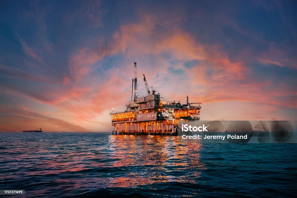 Vibrant Sunset Sky Behind an Offshore Oil Drilling Rig off the Coast of Orange County, California A stunning sunset photo showcases offshore oil drilling in Huntington Beach, California, with vivid hues casting a glow on industrial equipment Offshore Platform Stock Photo Vibrant Sunset Sky Behind an Offshore Oil Drilling Rig off the Coast of Orange County, California A stunning sunset photo showcases offshore oil drilling in Huntington Beach, California, with vivid hues casting a glow on industrial equipment Offshore Platform Stock Photo