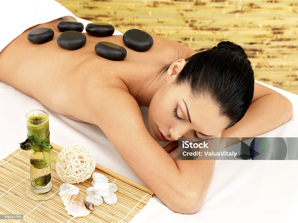 Stone massage for woman at  spa salon. Stone massage for young woman at beauty spa salon. Recreation therapy. Adult Stock Photo