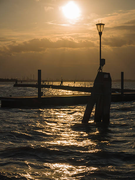 Sunset over the lagoon of Venice with bollards appearing as silhouettes