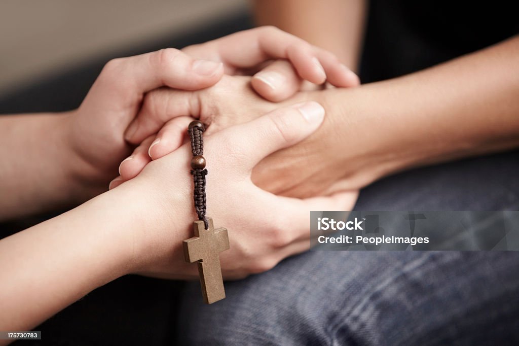 Their faith is strong Hands holding a Rosary while holding each other Adult Stock Photo