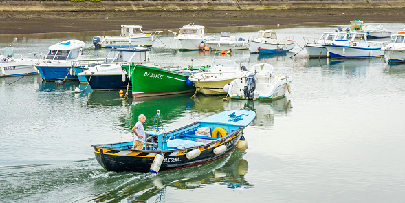 Man sailing in the marina of St Jean de Luz on the Nivelle river in France
