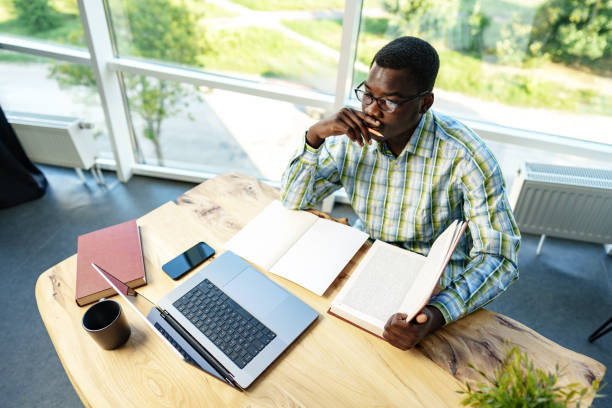 istock Serious concentrated african man studying or working with laptop indoors 1757348060