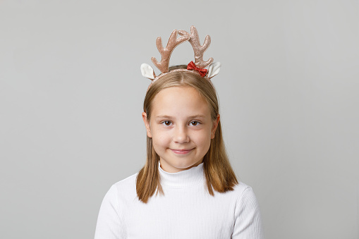 Happy Christmas child girl in hairdeco smiling on white background