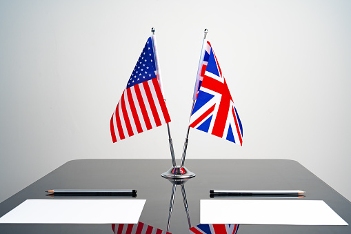 Flags of USA and United Kingdom on negotiation table close up