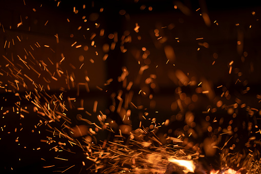 The texture of the fire. Sparks in the dark. Flames on a black background. Small sparks.