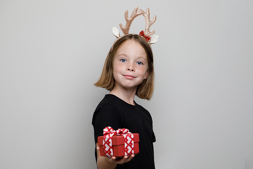 Happy adorble kid taking red present box on white background