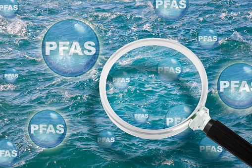 PFAS Contamination - Alertness about dangerous PFAS per-and polyfluoroalkyl substances into the sea waters - They are now everywhere, so much so that they have even been found in marine aerosol - Concept with magnifying glass