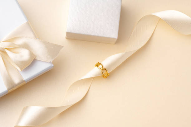 Golden jewelry ring on ribbon studio shot close up