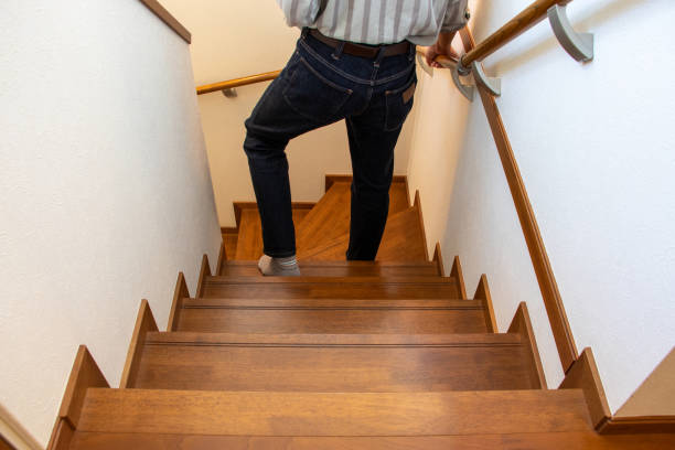 A man descending the stairs while holding the handrail