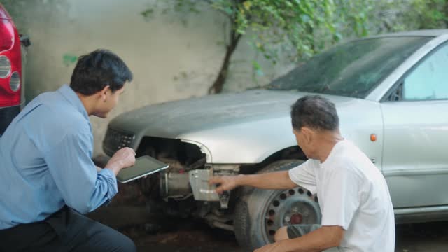 A senior man explains to the insurance agent what happened in a car accident