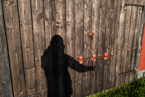 Shadow of a man on a wooden door