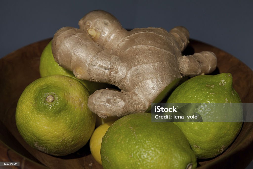 Green lemons and ginger in a wooden bowl Bowl Stock Photo