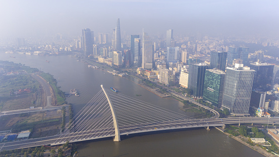 Aerial view of Ho Chi Minh city skyline with buildings, roads, bridge and Saigon river in Vietnam in the morning. Travel and business concept.