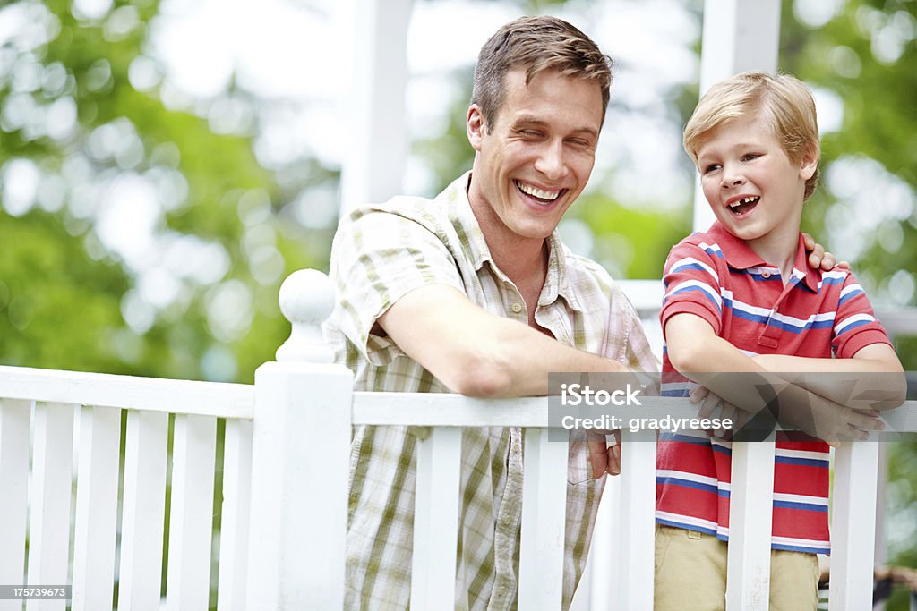 Sharing a laugh A young boy and his father sharing some quality time together on the porch Adult Stock Photo