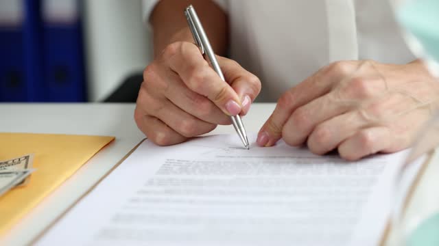 Businesswoman signing document holding pen puts signature on legal document