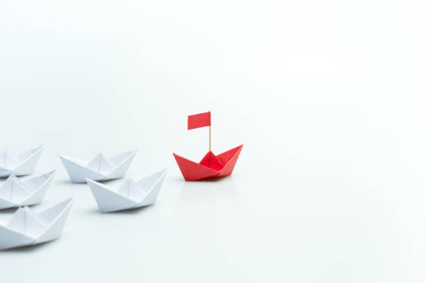 istock Red paper ship leading among white on white background, Leadership concept 1757410345