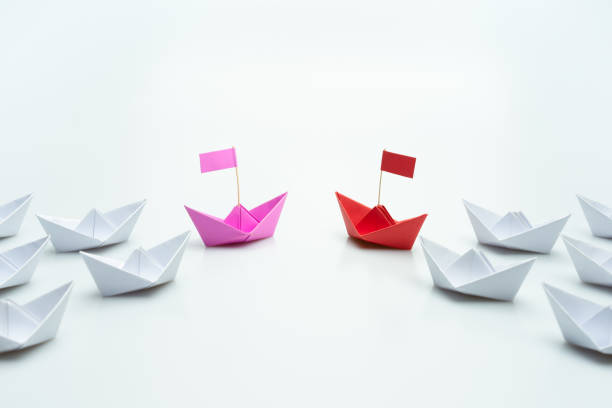 istock Red and pink paper ship leading among white. Equality or Competition for leadership between men and women concept. 1757410354