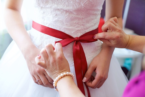 Elegant female hands of bride in white dress