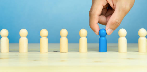 istock Select team leader, staff, human resources and management concept. Businessman hand choose wooden figure person standing out from the crowd on the table, copy space 1757426800