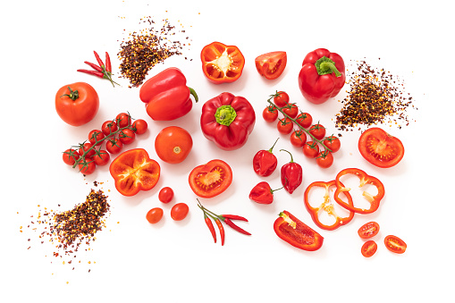 Top view of a large group of red vegetables such as various kinds of tomatoes and peppers isolated on white background