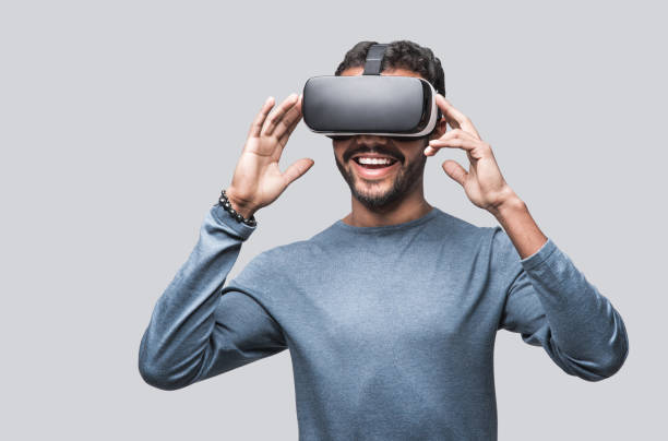 istock Young man using virtual reality eyeglasses headset, isolated on gray background 1757441119