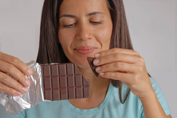 istock woman break dark chocolate bar. 1757442229