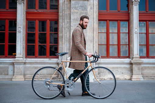 Young hipster businessman going to work on bike. High quality photo
