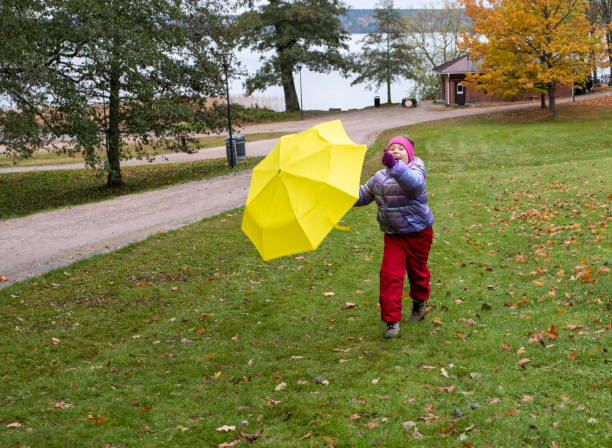 enfant, fillette caucasienne, 8 ans, lors d’une promenade automnale. un enfant avec un parapluie jaune vif saute de joie et se réjouit en automne. - female 8 9 years child excitement photos et images de collection
