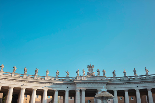 statues on the arch on the Saint Peter Square in the Vatican in Rome, blue sky background
