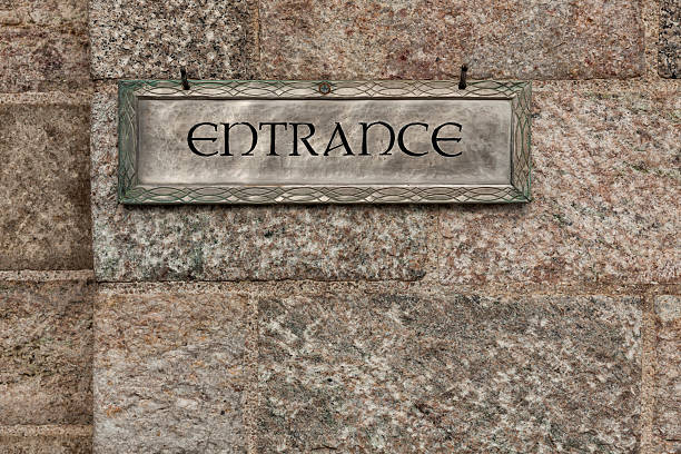 A pewter entrance sign displays an upscale look against a textured stone wall.