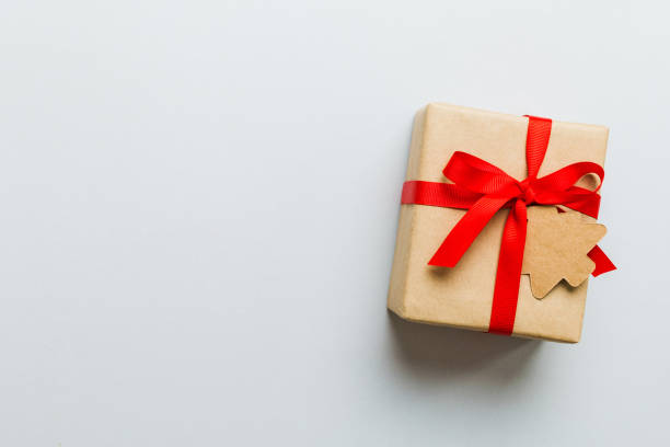 istock wrapped christmas or other holiday handmade present in paper with colored ribbon. Present box, decoration of gift on colourfull table, top view with copy space 1757455355