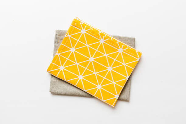 istock top view with yellow empty kitchen napkin isolated on table background. Folded cloth for mockup with copy space, Flat lay. Minimal style 1757455357