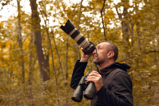 istock Man using binoculars and camera for birdwatching and other observing animals in nature. 1757463151