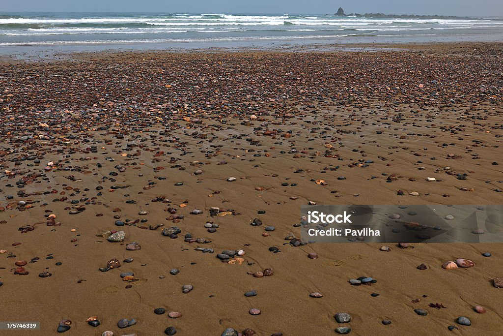 Moroccan Beach with Multi Colored Pebbles Multicolor pebbles on sand beach, Atlanric Ocean, Sidi Ifni, Morocco, Africa. Africa Stock Photo