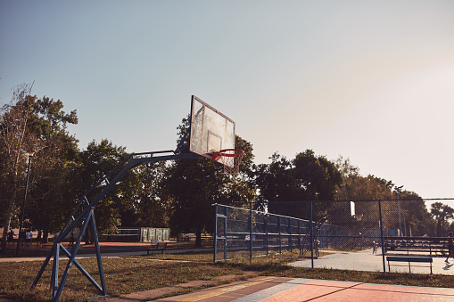 Public outdoor basketball court in summertime.