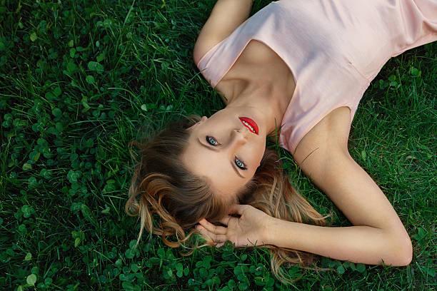 istock Young woman lying on grass 175746912