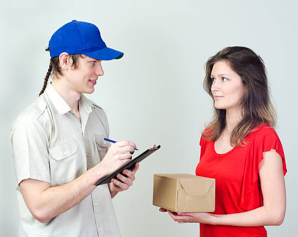 istock Young courier deliver package to pretty woman 175748172