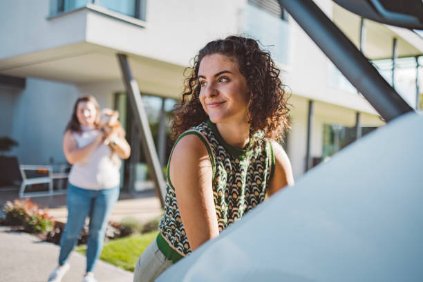 istock Two friends packing and loading luggage into car trunk for their vacation. 1757483996
