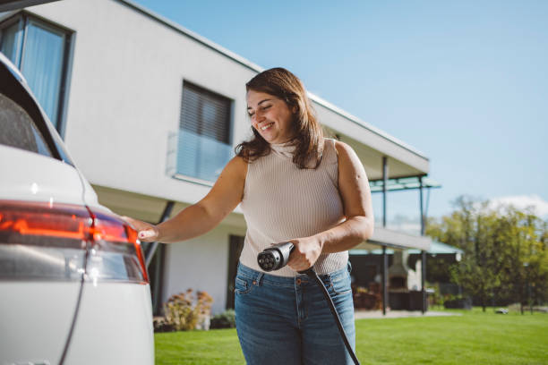 istock Woman charging electric car at front yard 1757487997