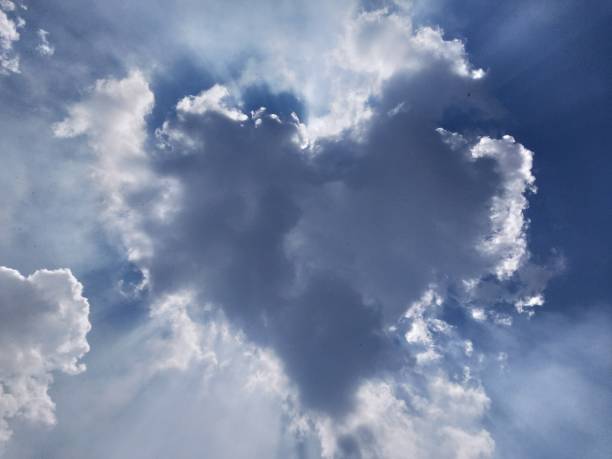 istock Beautiful Heart Shaped cumulus clouds visible with sun rays 1757490745