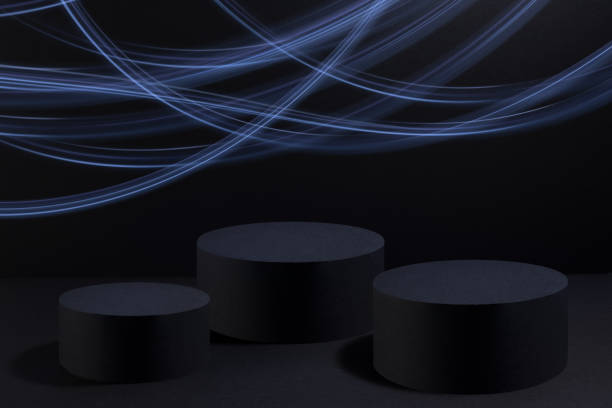 化粧品のモーショントレイルとして輝くネオンブルーのライトストライプを持つ抽象的な3つの黒い丸い表彰台、黒い背景にモックアップ。製品を表示するためのパーティースタイルのブラッ - version 3 flash ストックフォトと画像