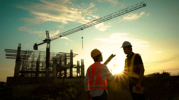 istock Silhouette of team engineer using laptop to control work, crane, construction site 1757499647